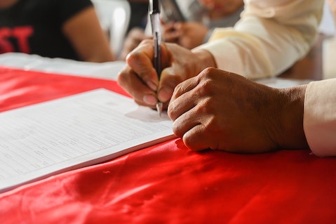 man signing guarantor agreement for loan