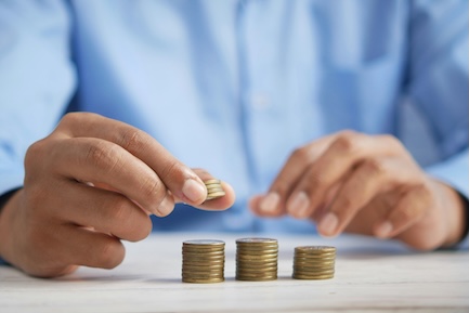 person adding up cash on table